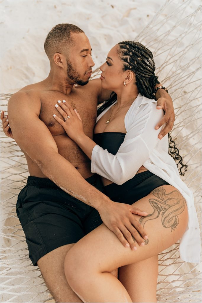 black couple embracing in hammock on beach