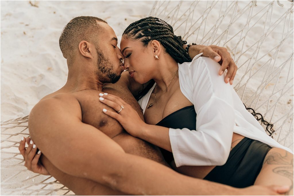 couple snuggling in hammock on beach