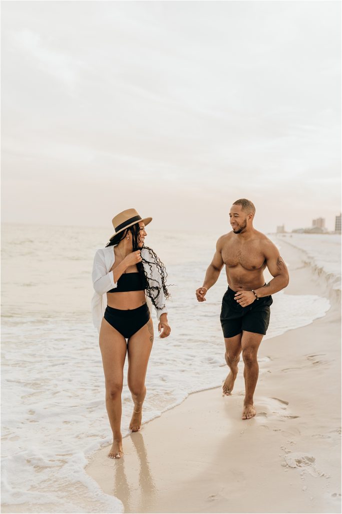 couple running in ocean in swimwear