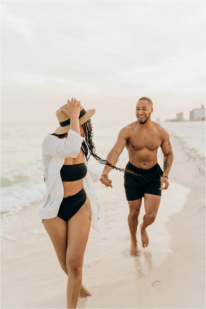 girl looking back at boy on beach in swimwear
