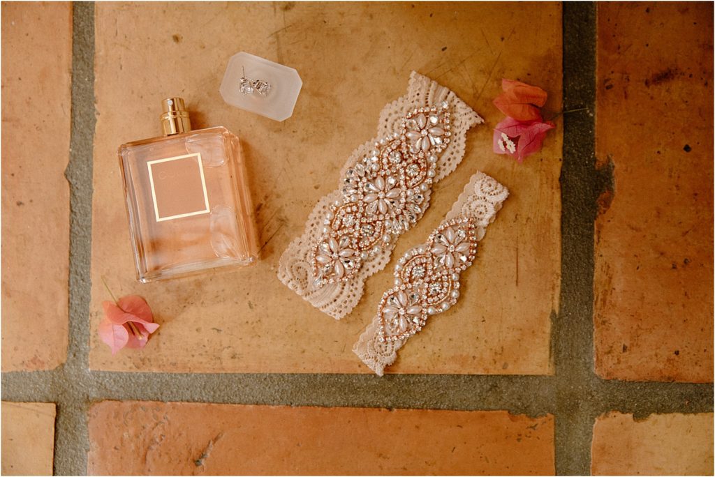 Bride's garter and perfume on tile floor at backyard palm springs wedding venue