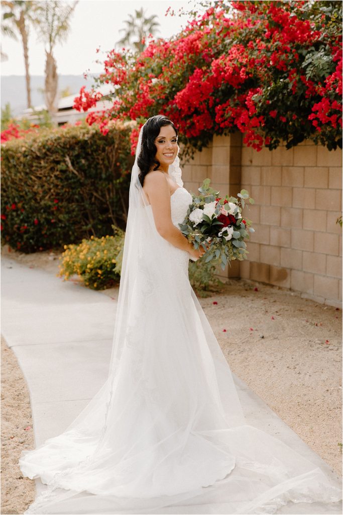 bride in front of flowers at backyard palm springs wedding venue