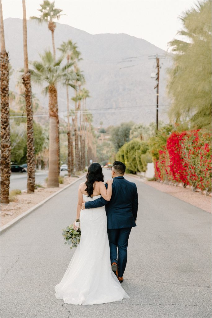 wedding couple walking along street at backyard palm springs wedding venue