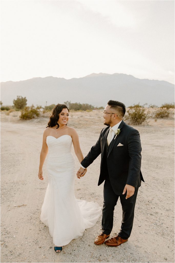 wedding couple walking along palm springs desert