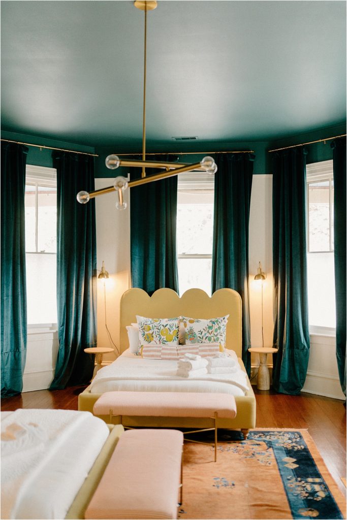 Gingerbread House Wedding Venue green bedframe with teal velvet curtains