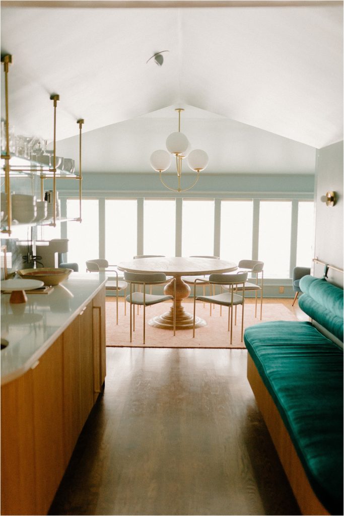 Gingerbread House Wedding Venue kitchenette with round dining table and teal velvet bench seating